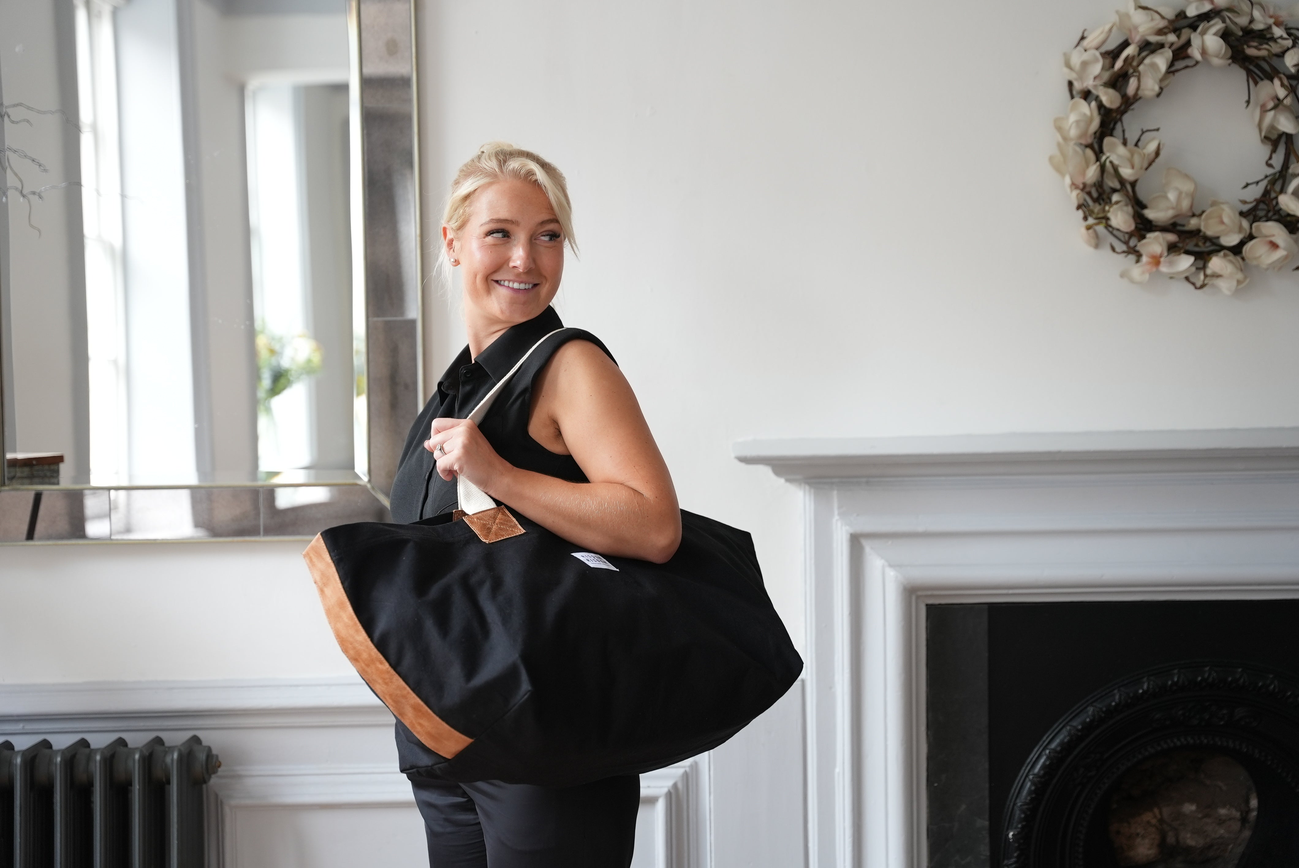 A lady carrying risdon and risdon canvas and leather market bag made in england.