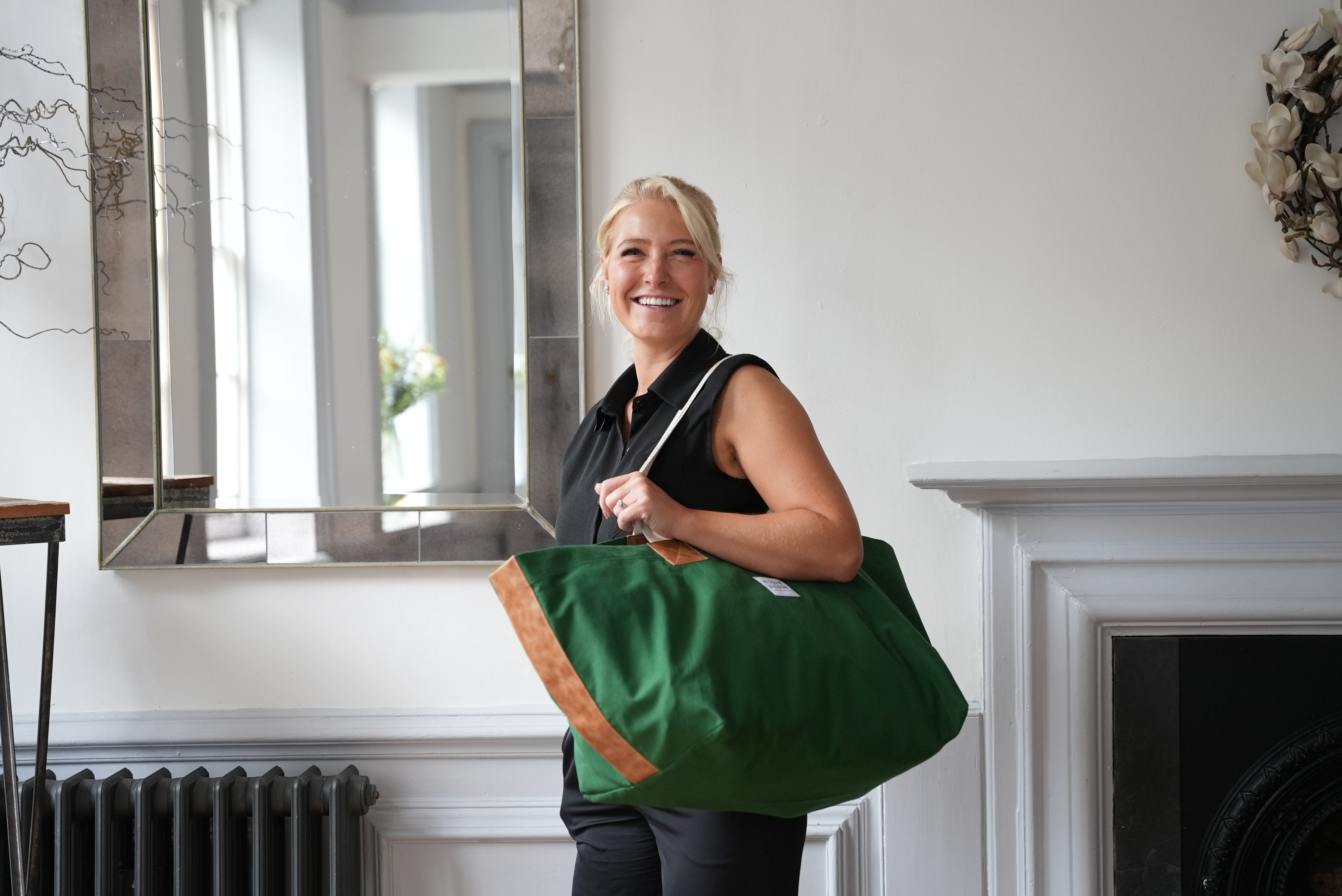 A lady carrying risdon and risdon canvas and leather market bag made in england.