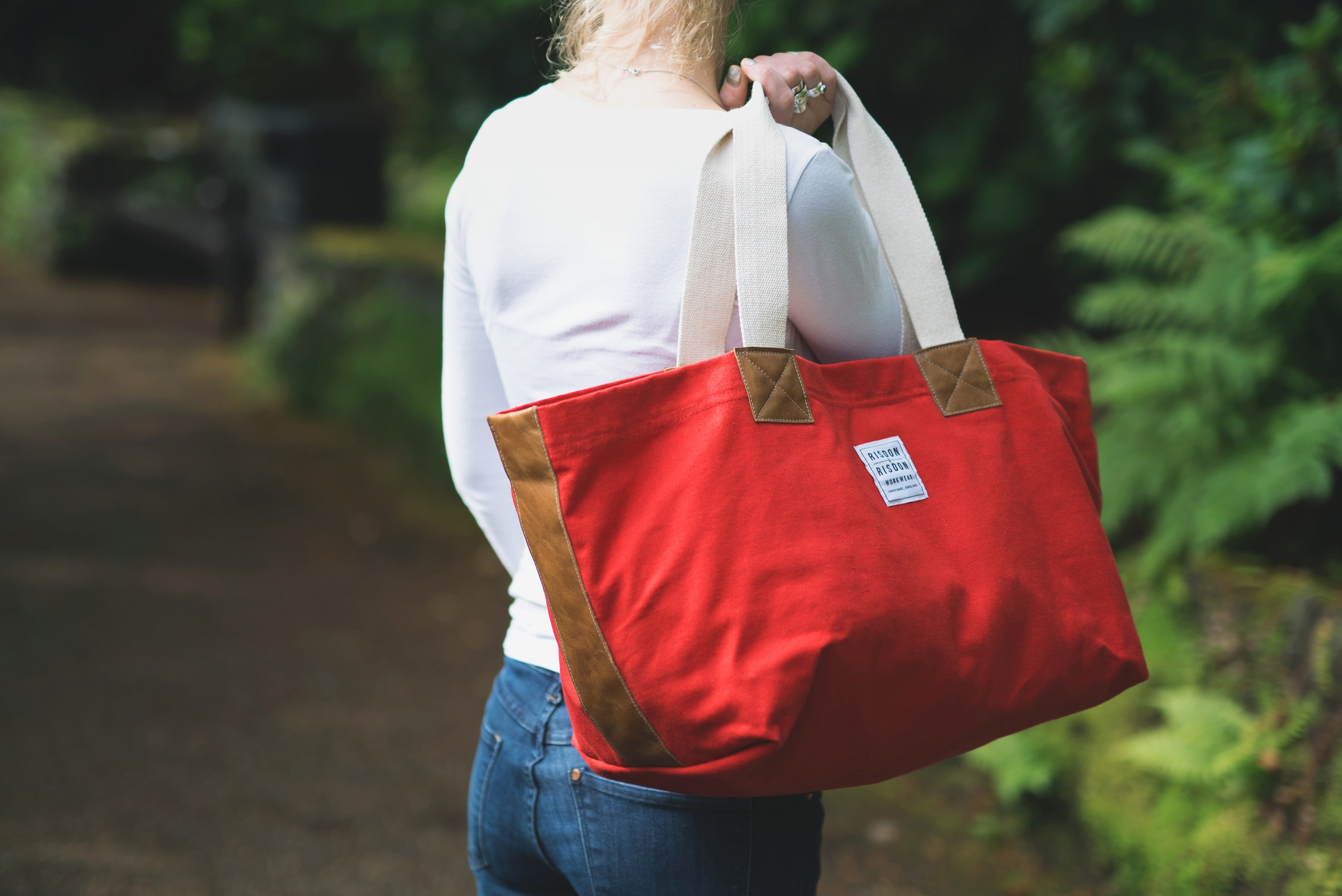 A lady carrying risdon and risdon canvas and leather market bag made in england.