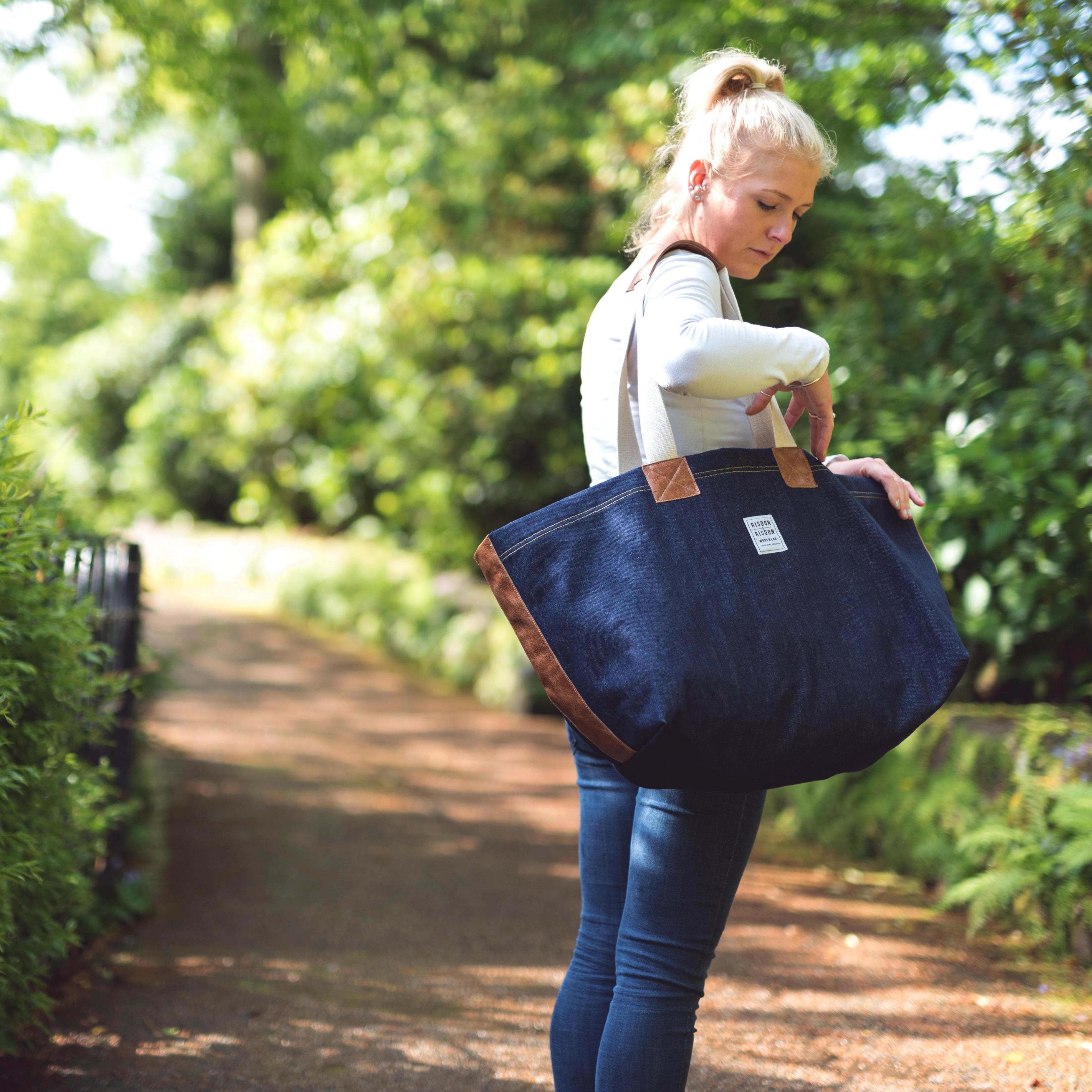A lady carying a risdon and risdon denim market bag made in england