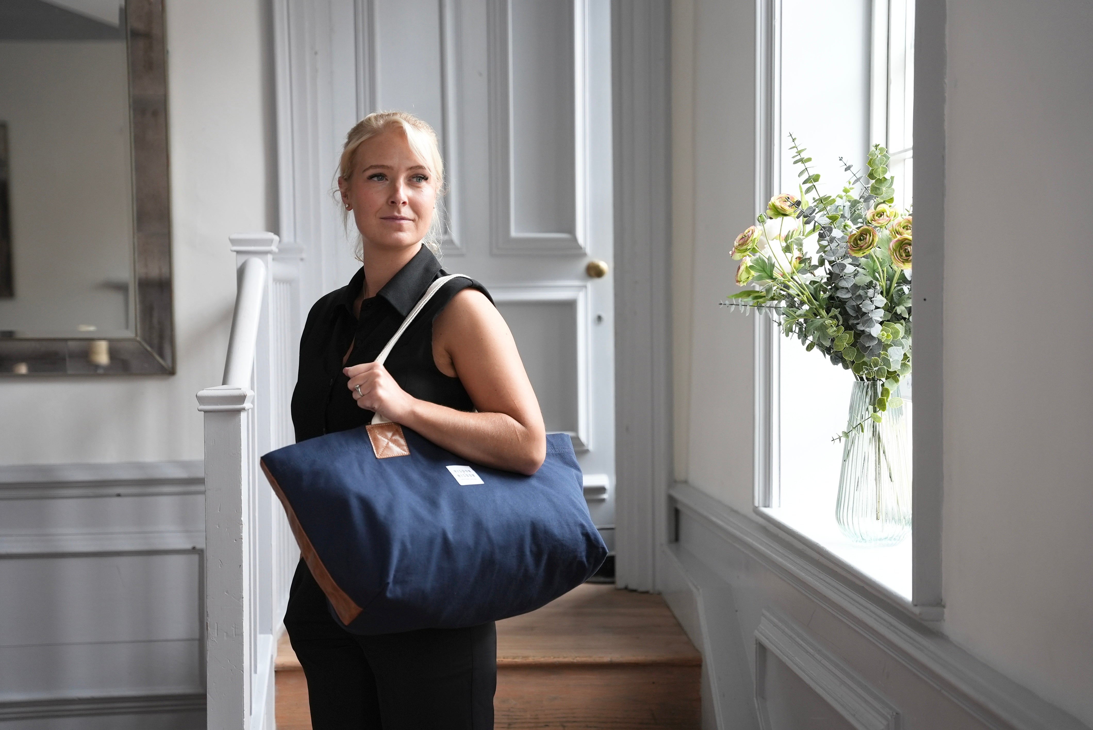 A lady carrying risdon and risdon canvas and leather market bag made in england.