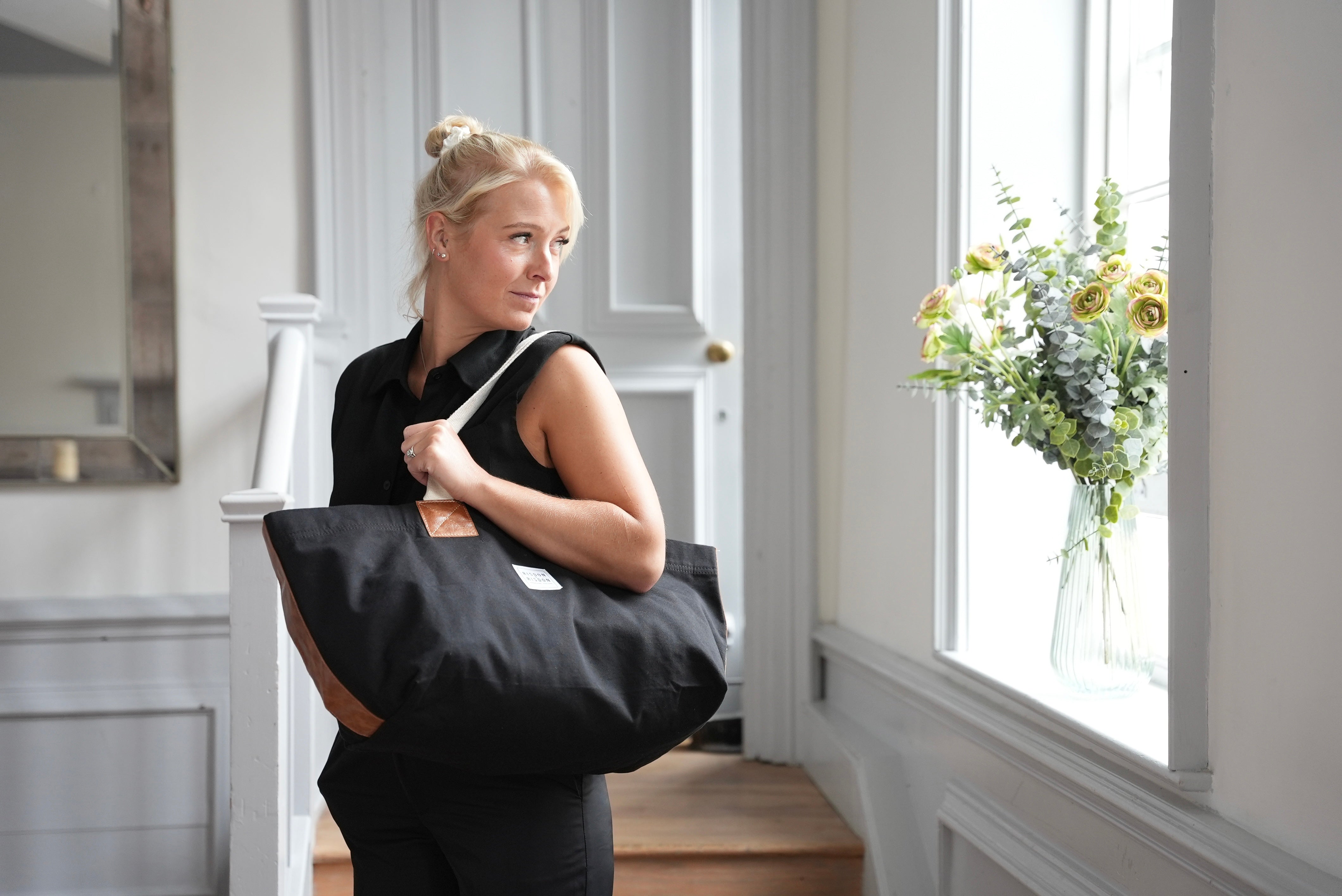 A lady carrying risdon and risdon canvas and leather market bag made in england.