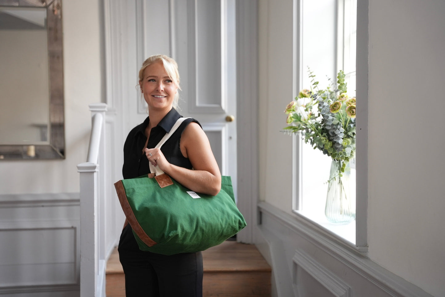A lady carrying risdon and risdon canvas and leather market bag made in england.